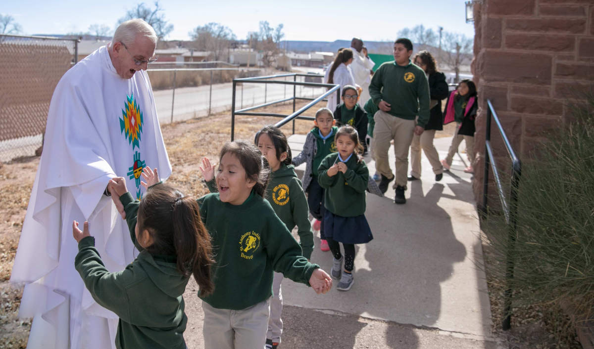 Father McGuire Greeting Children